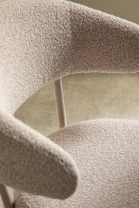 Elegantiškų linijų valgomojo kėdė ORVUINO bouclé prie valgomojo stalo