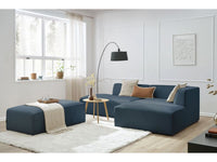 Kampinė modulinė sofa su pufu, tamsiai mėlyna šalia kavos staliuko