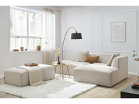 Kampinė modulinė sofa su pufu, smėlinė šalia kavos staliuko