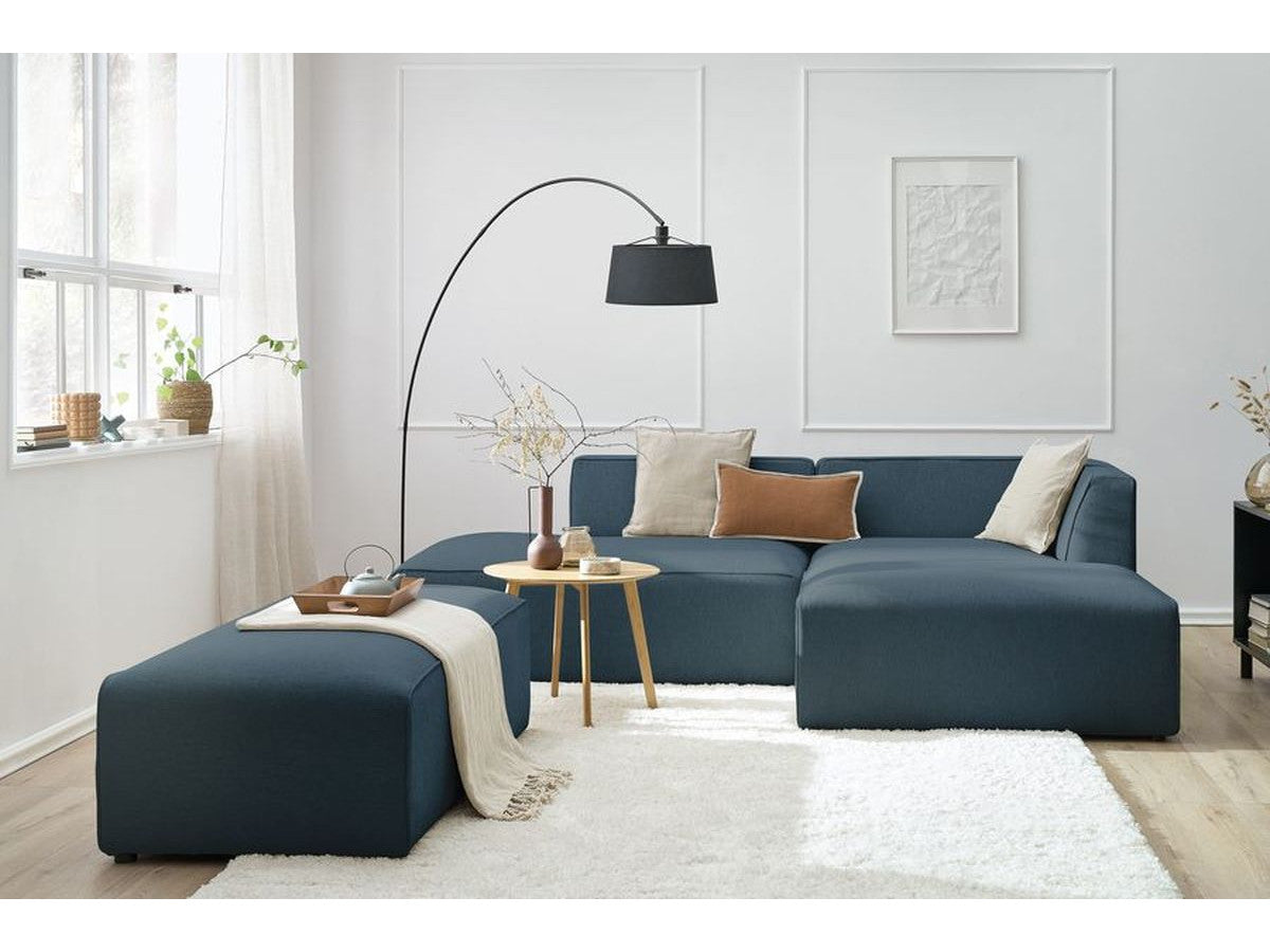 Kampinė modulinė sofa su pufu, tamsiai mėlyna svetainės interjere