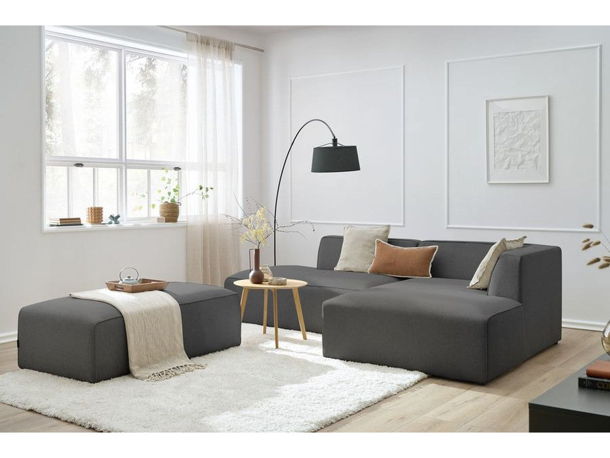 Kampinė modulinė sofa su pufu, tamsiai pilka šalia kavos staliuko