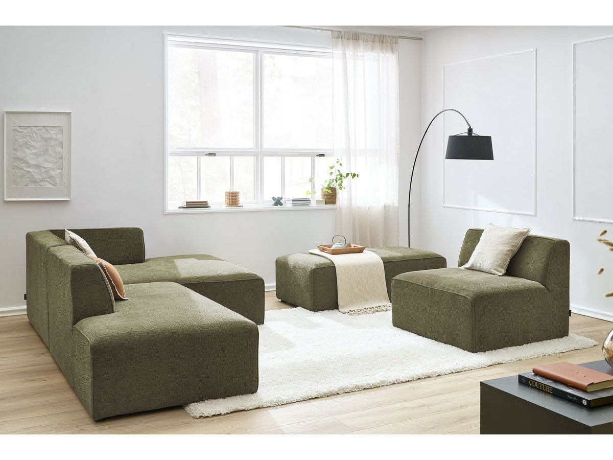 Kampinė modulinė sofa su pufu ir žalia svetainės interjere