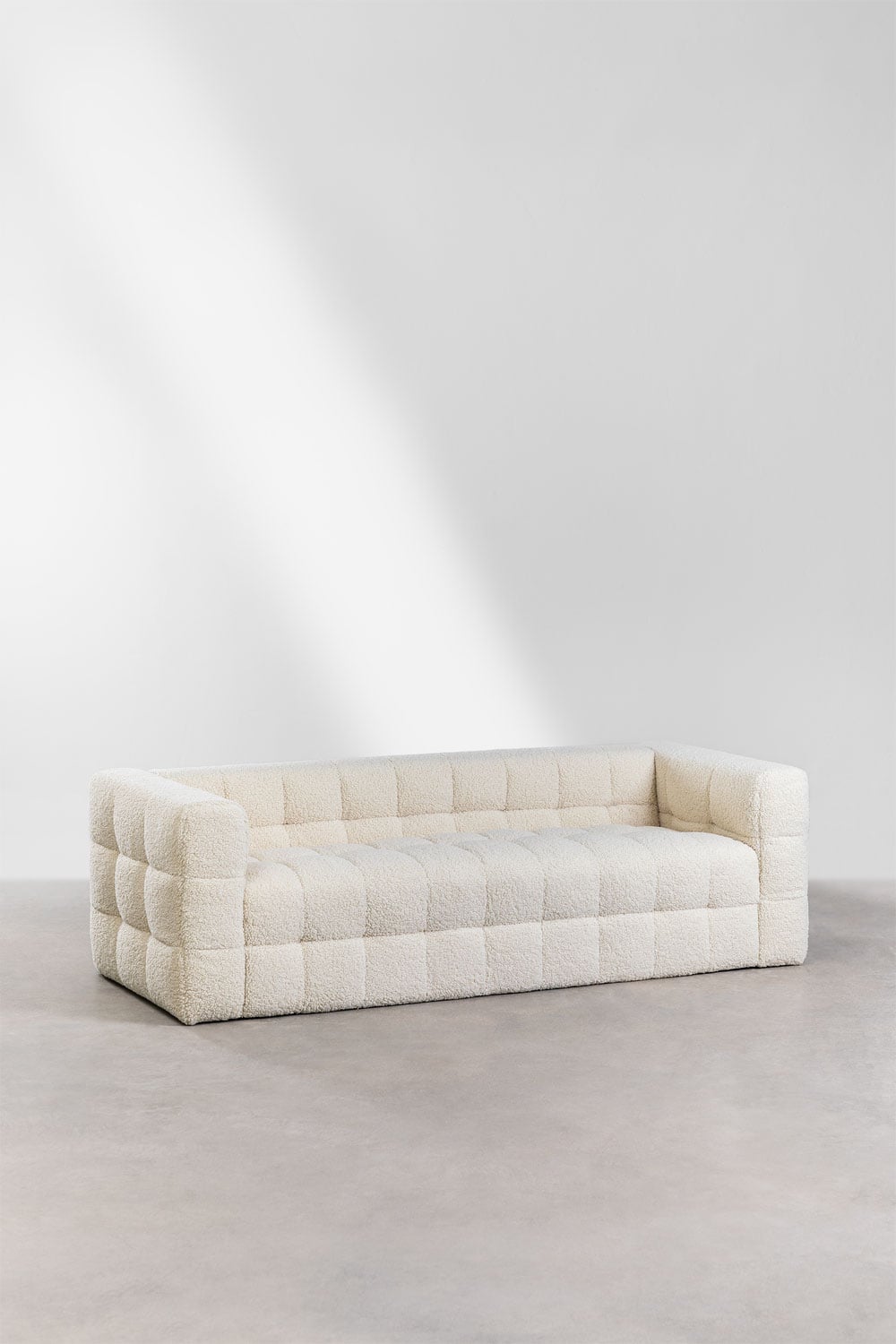 Trivietė sofa šviesiame svetainės interjere