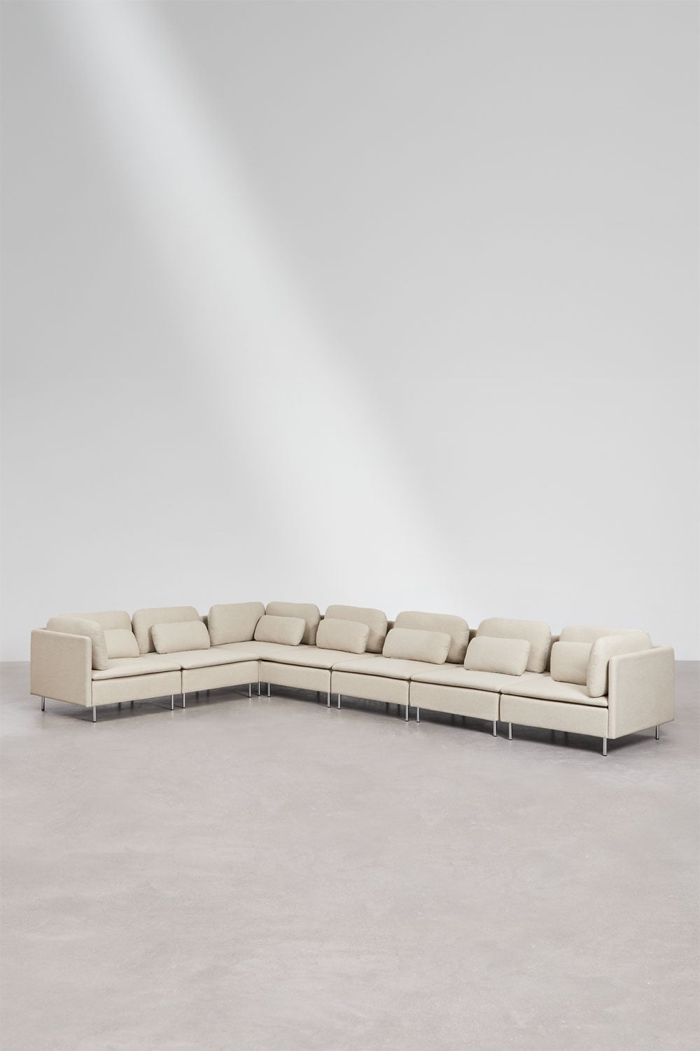 Kampinė sofa ORIOLA interjere su dekoro elementais